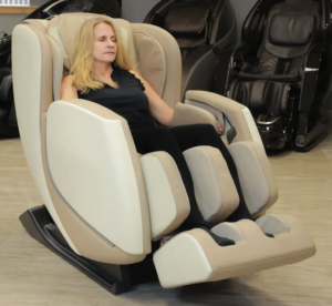 A member of the Massage Chair Store Review Team reclines on a cream and tan colored Kyota E330 Kofuko massage chair.