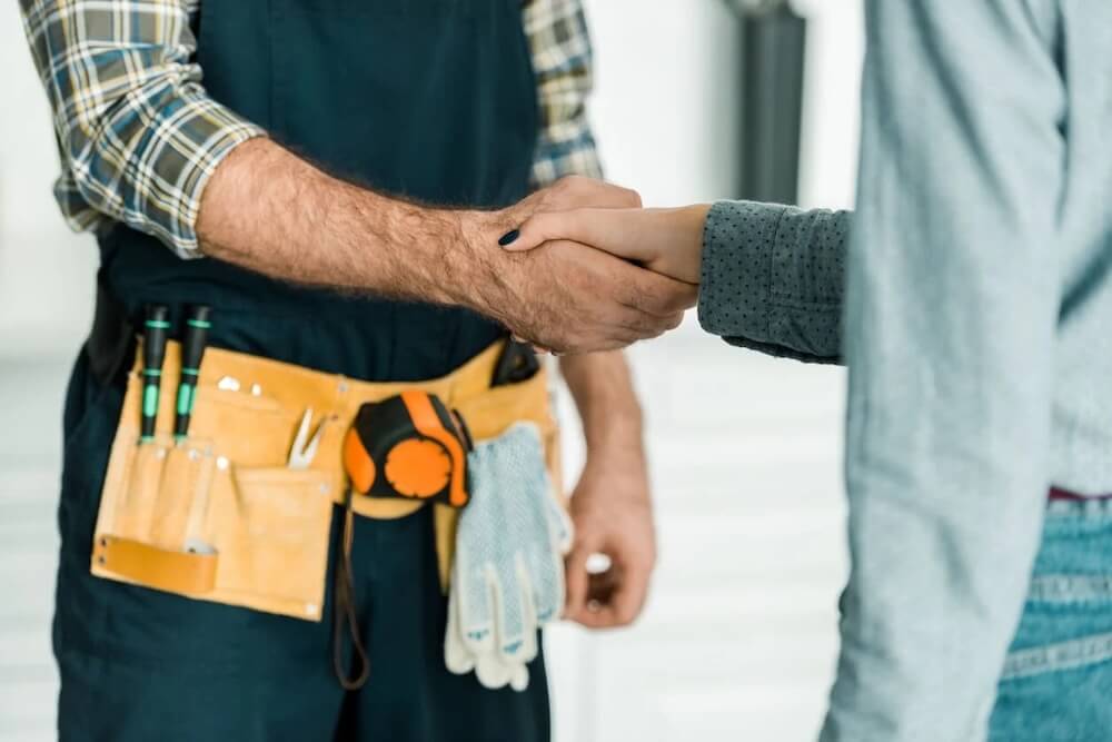 a repairman shaking hands with a customer