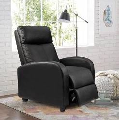 Partially reclined recliner with black leather upholstery in a room with white brick walls and colorful pastel rug.