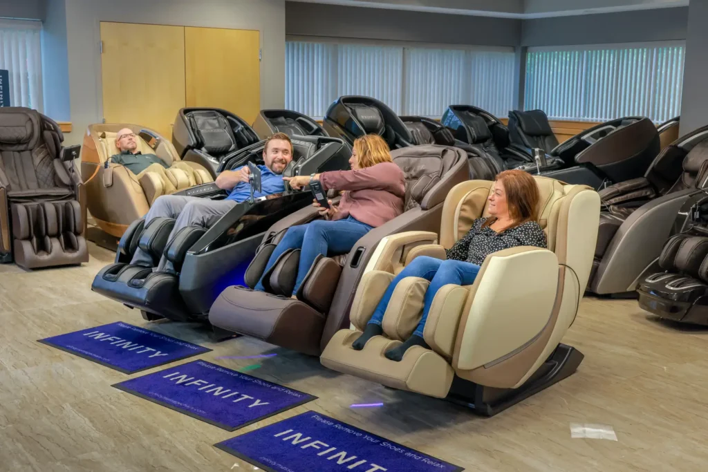 Four members of the MCS review team sitting in and testing different massage chairs within the Massage Chair Store show room.
